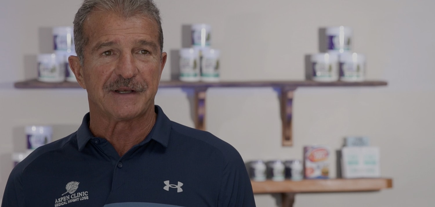 Man speaking in front of product display.
