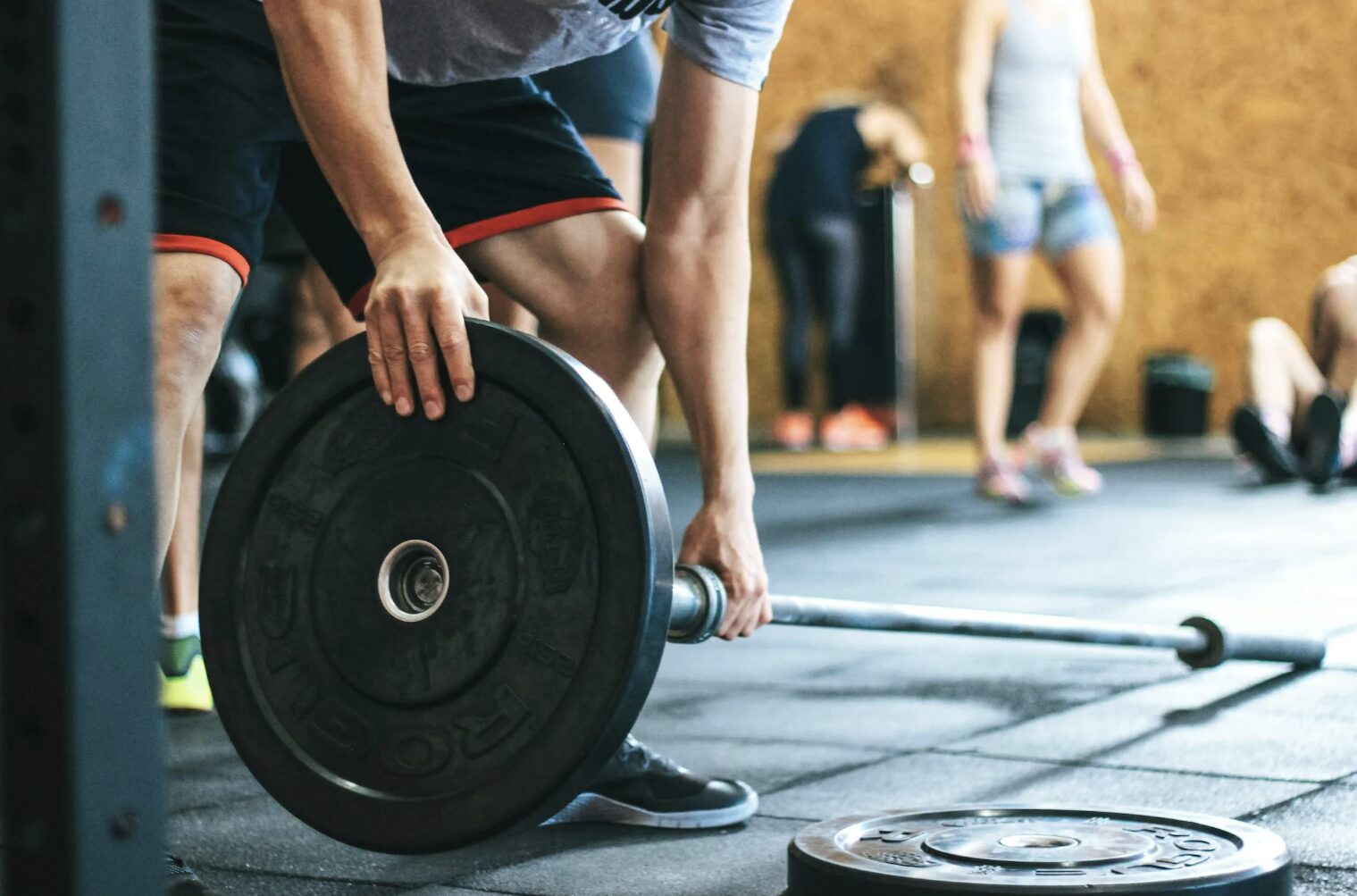 Man Assembling Barbell in Gym